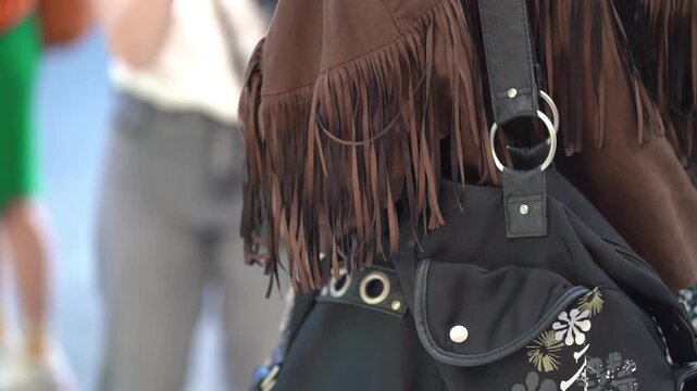 girl wearing cowboy jacket and black leather handbag