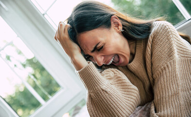 Portrait of shouting female with bipolar disease. Depressed, frustrated, angry, lonely, emotional young woman with severe stress and mental problem, disease, headache, illness, victim of violence