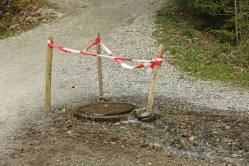 Emergency water supply, sewerage. Water pours out from under the road drain.