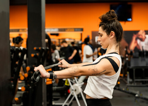 Young woman training in a busy gym environment
