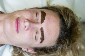 Woman receiving microblading eyebrow treatment