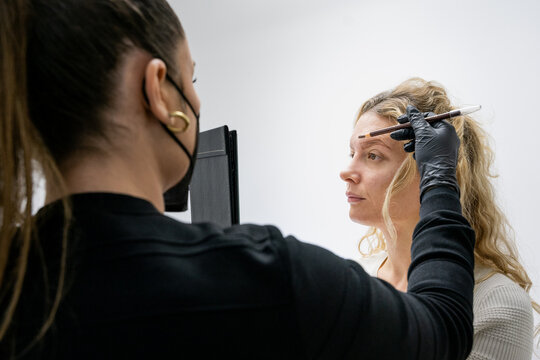 Beautician explaining and preparing for microblading