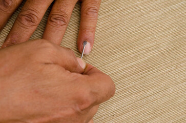 a man uses a cuticle pusher to give himself a manicure
