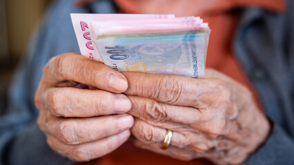 Old woman counting Turkish lira banknotes