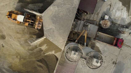 Process of concrete manufacturing with cement, water, sand and gravel at factory. Aerial top down