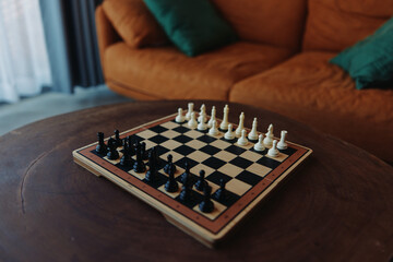 Chess board on table in front of living room couch in cozy home interior