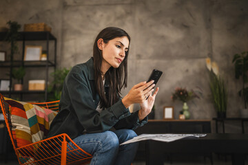Portrait of adult young woman sit and use mobile phone take a break