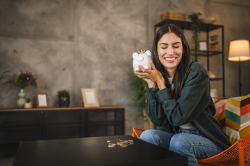 Portrait of happy adult woman hold piggy bank and smile, enjoy