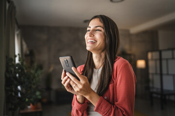 Portrait of adult young woman stand hold and use mobile phone