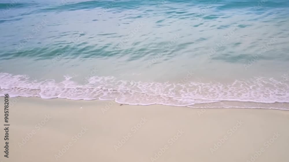 Poster soft waves touch the shore as the sun rises, illuminating the calm beach with pale colors, creating 
