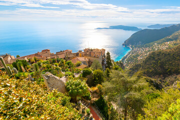 Naklejka premium View of the medieval hilltop Eze Village with the Mediterranean sea, hills, coastline and town of Eze, France in the distance, along the Cote d'Azur French Riviera of Southern France. 