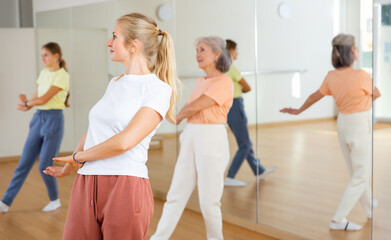 Obraz premium Smiling female doing dance workout during group classe in fitness center