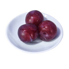 Three ripe plums on a white saucer isolate on a white background.