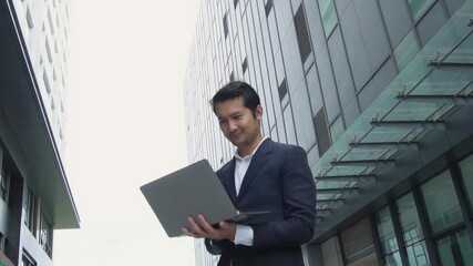 Asian businessman working at laptop showing joy and showing success in investing in financial business investment or wealth.