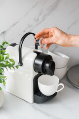 Person hold coffee pod close to espresso machine
