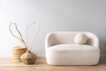 White sofa with dry wooden branches in wicker vases