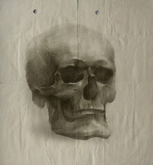 A pencil drawing of a skull on old crumpled paper.
