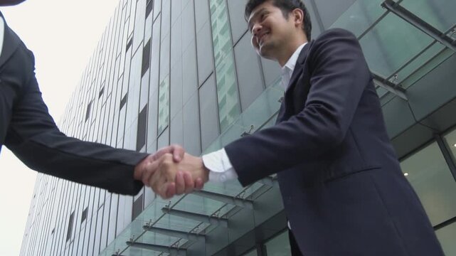 Asian businessman showing smile and joy in shaking hands with business partner, concept of cooperation to make business successful and having connection to connect business to success.
