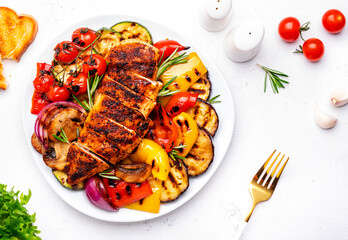 Summer BBQ appetizer with chicken breast, vegetables and mushrooms, white background, top view