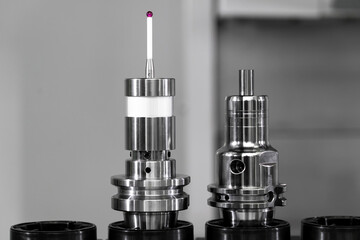 Two precision engineering components are showcased on a workbench, highlighting their detailed designs and functionality