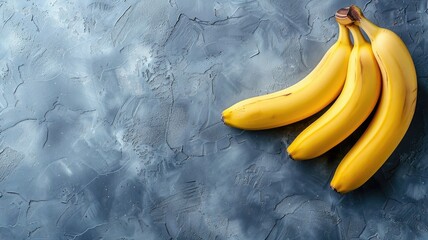 Four ripe bananas are placed on textured grey background
