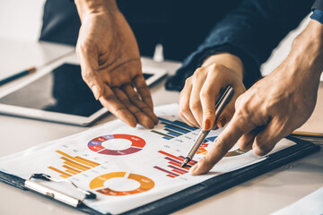 Businessman and businesswoman in meeting working with many financial statement document on desk. Concept of busy business profit analysis and brainstorm. Close up shot at people hands and papers. uds