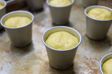 カップに入ったオーブンで焼く前の酵母で作ったパンの生地