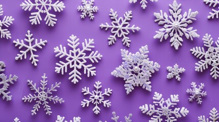 Snowflake pattern with glitter on purple background for Christmas concept viewed from above