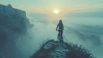 Fototapeta premium Woman on a Bike overlooking a Foggy Valley at Sunset