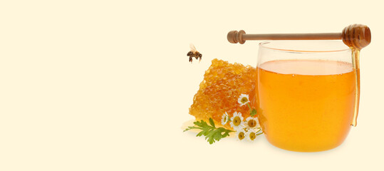 Organic honey in glass jar, wooden dipper and honeycomb on beige background. Banner design with...