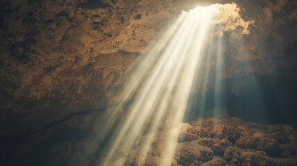 Bright rays of sunlight pierce through a cave entrance, casting dramatic shadows on the rocky floor