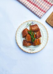 Boiled Cassava with Palm Sugar, is a traditional Indonesian dessert made from boiled cassava, combining the sweetness of brown sugar and the soft texture of cassava. Served on a white background.