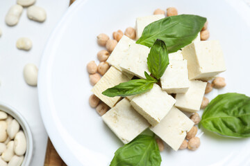 Tofu in a bowl with beans and soy on a light background