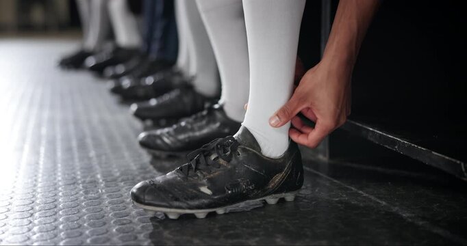 Football, locker room and man with massage of leg for sports injury, pain and swollen ankle. Athlete, foot and hand of player with boots on floor for muscle strain, inflammation and accident in match
