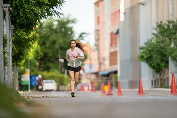 Obraz premium A woman runs down a street with a car behind her