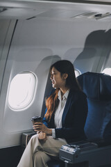 Asian woman sitting in a seat in airplane and looking out the window going on a trip vacation travel concept.Capture the allure of wanderlust with this stunning image