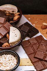 Chocolate chip cookies, dark and white chocolate bar, small bowl of oatmeal and nuts. International Chocolate Day.