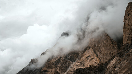 An Alpine Himalayas Rocky Mountain landscape of cloudy rocky stone shrouded in thick clouds and Snow with cloudy, stormy and wilderness background and texture in Gilgit-Baltistan, Pakistan
