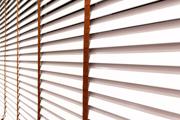 Stylish white wooden blinds on the window. Detailed furniture for modern interior