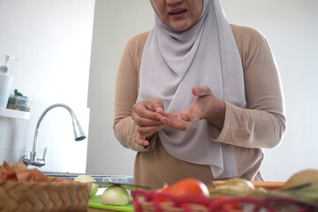 Woman hurt herself, cut her finger by accident while cooking in kitchen