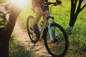 Woman biker mountain biking on mountain forest trail