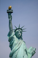 Fototapeta premium The Statue of Liberty holding her torch on a sunny day in Manhattan