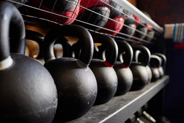 Close up background image of kettlebells in row on equipment rack in weight training gym copy space