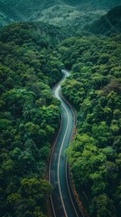 Aerial View of a Winding Asphalt Road through Lush Green Woods and Mountainous Terrain, Capturing the Essence of Rural Country Roads.