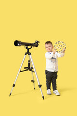 Cute little scientist with telescope and molecular model on yellow background