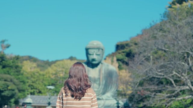 Woman tourist Visiting in Kamakura, Kanagawa, Japan. happy Traveler sightseeing the Great Buddha statue. Landmark and popular for tourists attraction near Tokyo. Travel and Vacation concept