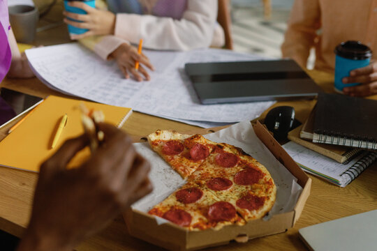 Creatice office workers lunch. Eating pizza at work. Friends meeting
