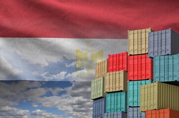 Egypt flag and big stack of shipping cargo containers in docks with sky background close up