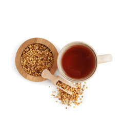 Cup of fresh buckwheat tea and wooden scoop on white background