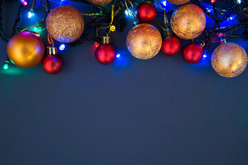 Gold and red Christmas baubles. Baubles lie on a blue background. 
Copy space. Close-up. Horizontal photo